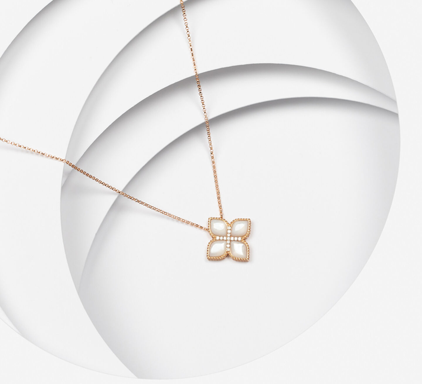 Gold necklace with a white flower shaped pendant